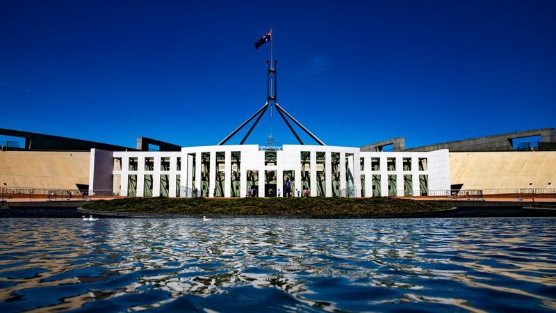 Australia's Parliament House in Canberra seen across the forecourt pool, flag flying from the mast